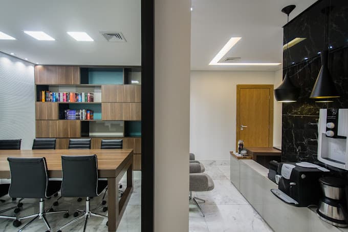 Sala de reunião do escritório, com estante e mesa de madeira